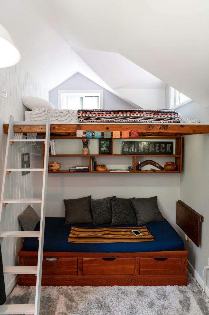 Chic loft bed with ladder in a stylishly decorated modern bedroom, perfect for compact living.